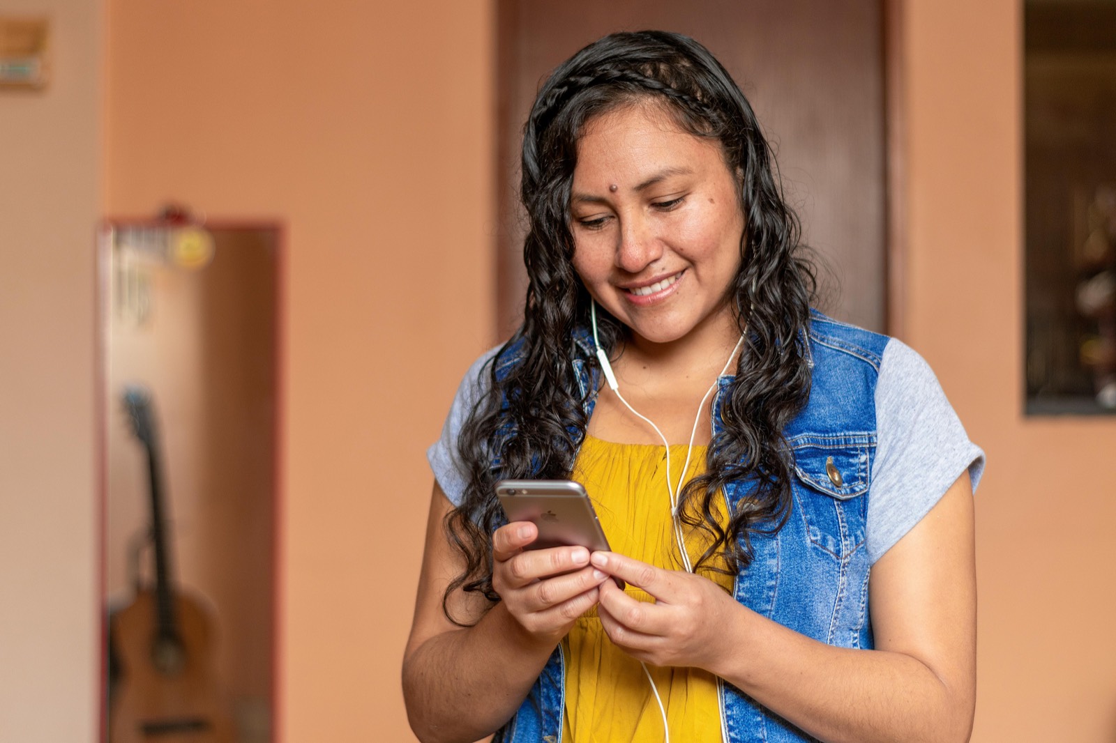Smiling woman with earbuds, focused inward