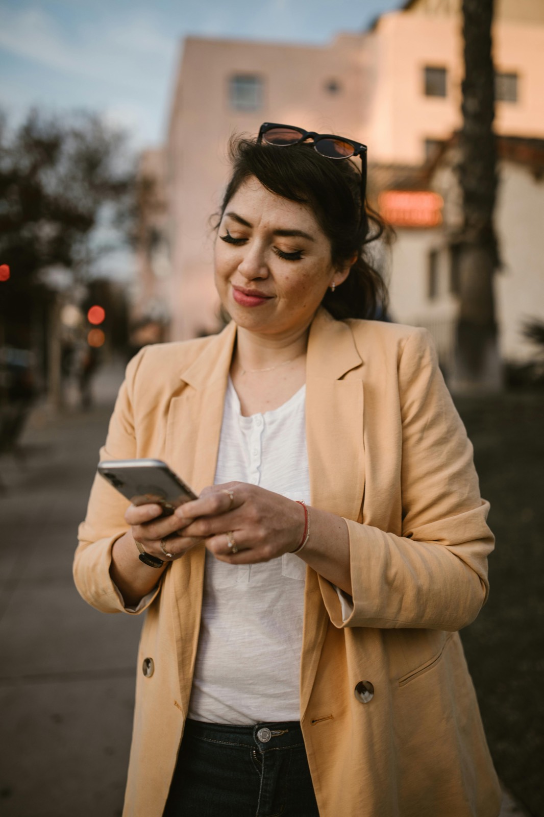 Working woman in tan blazer on her phone